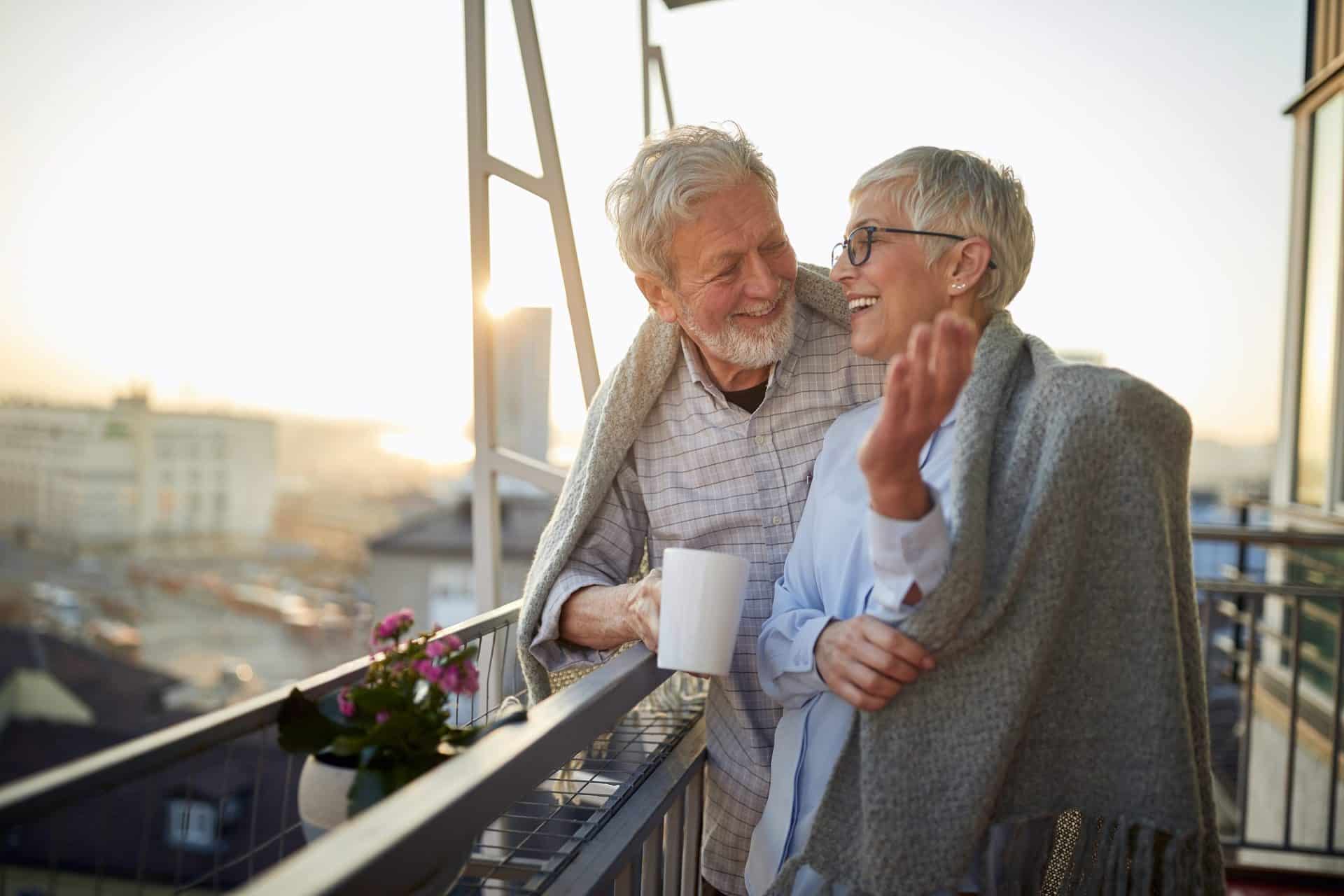 two elderly people are standing on balcony